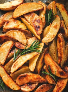 Fried potato slices, homemade, on parchment, burned, top view, close-up