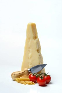 A piece of Parmesan cheese with cheese knife, tomatoes and pasta, Italy, Europe