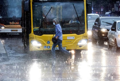 People run across Potsdamer Strasse in heavy rain. After weeks of heat, the first heavy rain
