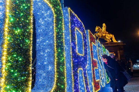 Augustusmarkt in Dresden. a woman looks through the illuminated sign DRESDEN, Dresden, Saxony,