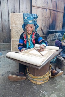 Vietnamese woman from the Hmong minority draws a pattern on linen fabric, Lung Tam linen weaving