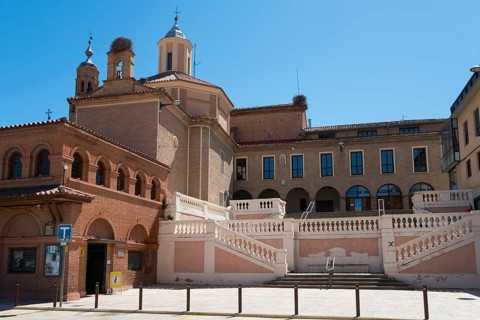 Historic church with stairs and brick façade under a blue sky, Iglesia y ex-convento de San