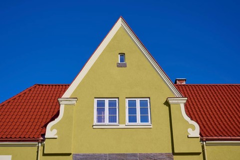 House gable with red tiled roof and white windows against a clear blue sky, Molde, Romsdal, Norway,