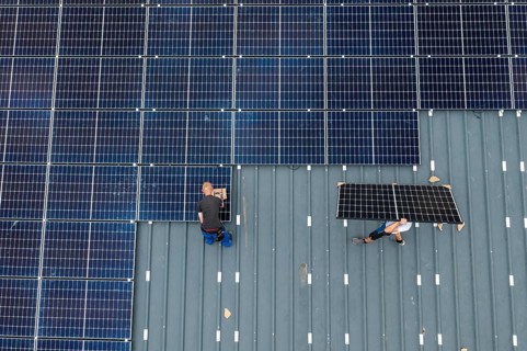 Installation of solar modules on the roof of a barn on a farm, over 210 photovoltaic modules are