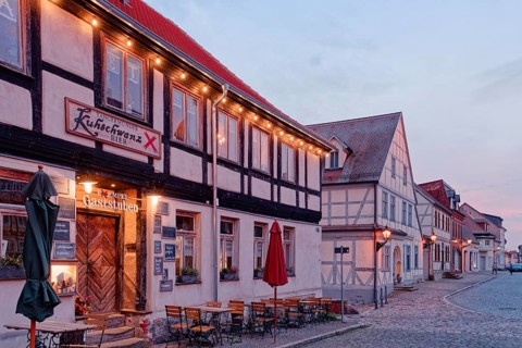 A festively illuminated restaurant in the evening and half-timbered houses in the cobbled