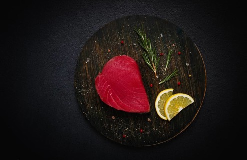 Fresh red tuna fillet, for steak, raw, top view, on a black plate, no people
