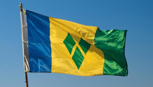 The flag of the Grenadines flutters in the wind, isolated against a blue sky