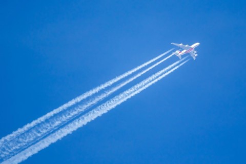 An Emirates Airbus A380-800 aircraft with registration number A6-EVN in flight with contrails over