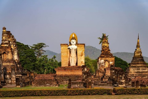 Giant standing Buddha in the Wat Mahathat temple in the UNESCO World Heritage Sukhothai Historical