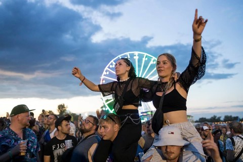 Festival visitors celebrate on shoulders during Ski Aggu's performance in front of the Ferris wheel