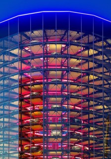 An illuminated car tower with new cars for delivery in the evening, Autostadt, Volkswagen AG,
