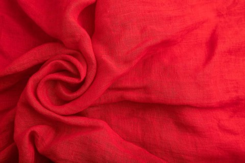 Fragment of red silk tissue. Top view, flat lay, natural textile background and texture. wave