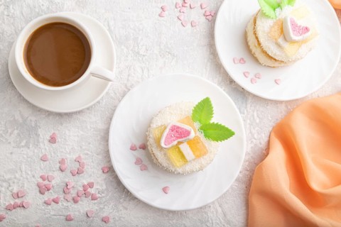 Decorated cake with milk and coconut cream with cup of coffee on a gray concrete background and