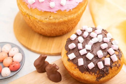 Homemade glazed and decorated easter pies with chocolate eggs and rabbits on a white concrete