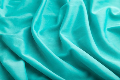 Fragment of silk blue tissue. Side view, natural textile background and texture. wave concept,