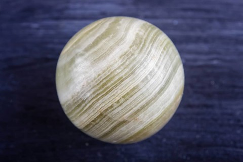 Green onyx sphere on a black background, close up