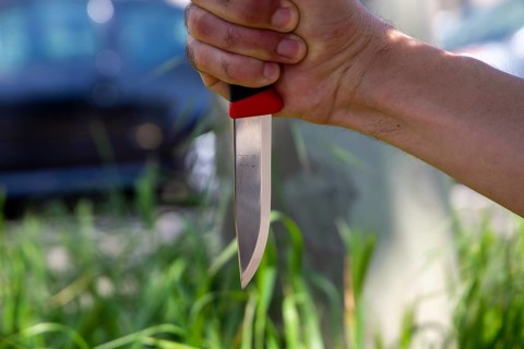 Symbolic image of a knife attack: close-up of a knife in a man's hand
