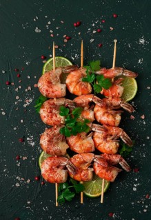 Shrimp kebab, with spices, lime, on wooden skewers, top view, no people