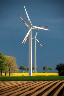 Wind turbines on a rape field, dark rain clouds, in the Rhenish lignite mining area, near
