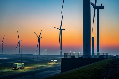 Lorry on the road from Euromax Terminal Rotterdam, ENECO wind farm on the dike around the port of
