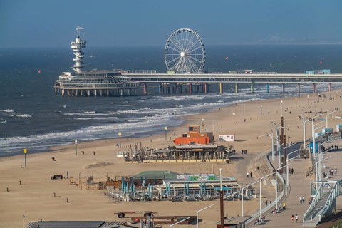 View over the beach of Scheveningen, the pier with Ferris wheel belongs to the city of The Hague