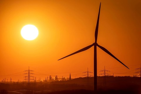 Wind turbine of the Emschergenossenschaft, view to the west, in Essen, sunset, behind the blast