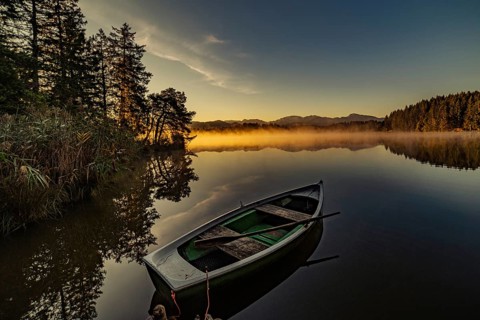 Boats in the autumnal Schmutter Weiher in the Allgäu near the municipalities of Halblech,
