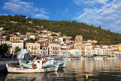 Small fishing boats in the Mediterranean harbour of Gythio or Gythion, behind houses and the
