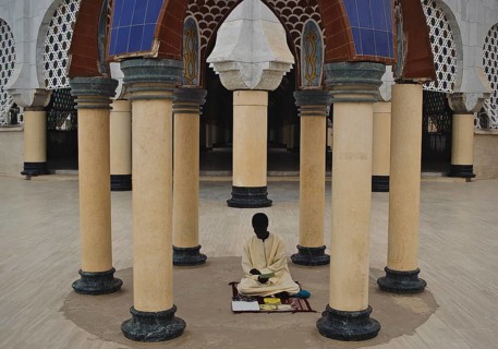 A muslim religious student is reading a book in the Great Mosque at Touba Senegal