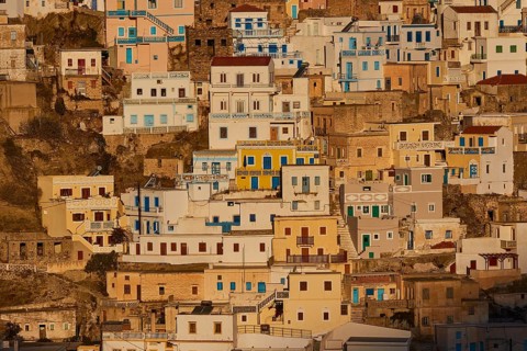 Densely built houses in bright colours on a sunny slope, Colourful mountain village, Morning light,