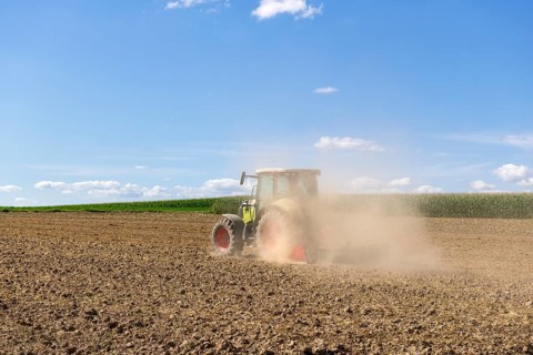 Symbolic image, global warming, dry soil, dust, farmer tilling a field, tractor, ploughing, clouds,