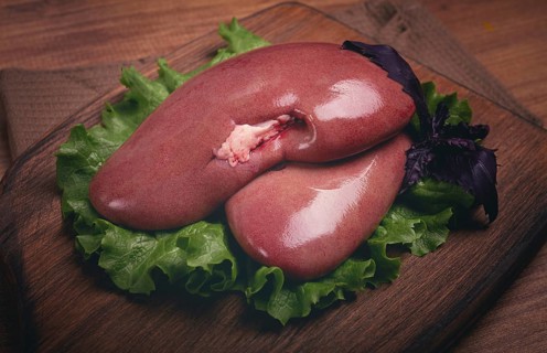 Raw pork kidneys, on a chopping board, close-up, top view, no people