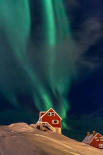 Northern Lights, Aurora borealis over red house, Inuit settlement, Winter, Tasiilaq, East