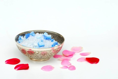 Bath salt in a bowl, rose petals