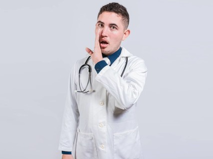 Young doctor whispering a secret on isolated background. Handsome doctor telling a gossip isolated,