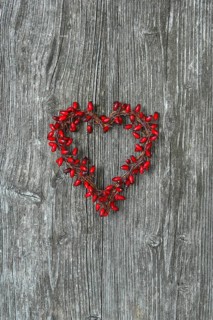 Heart-shaped rosehip wreath on wooden door