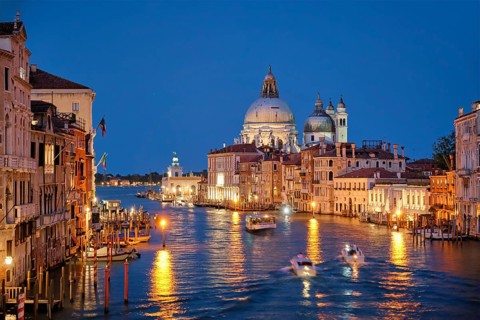 View of Venice Grand Canal with boats and Santa Maria della Salute church in the evening from Ponte