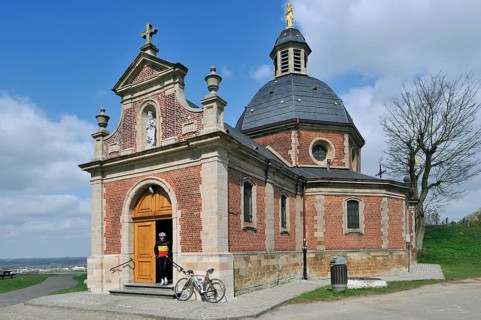 Cyclists leaving the chapel of Our Lady of the Old Mountain on the Muur van Geraardsbergen,