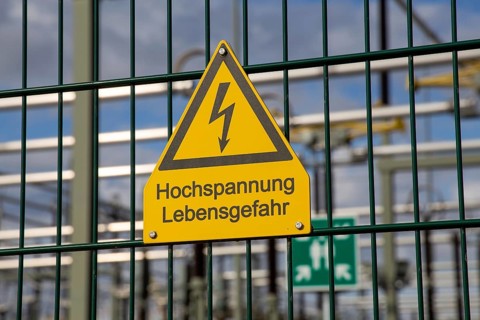 Symbolic image: Sign on the fence of a substation warning of danger to life