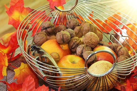 Apples, pears and walnuts on a rustic wooden table as an autumnal motif