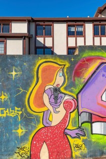 Colourful graffito of a woman with a gun, street art in the city of Punta Arenas, Patagonia, Chile,