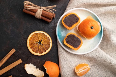 Truffle chocolate tangerine candies on a black concrete background and linen textile. top view,