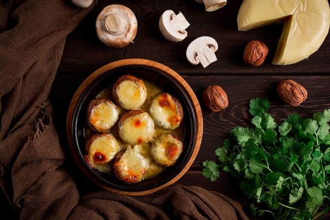 Traditional Georgian dish, appetizer, stuffed mushrooms, Sulguni cheese, baked in a Ketzi clay pan,