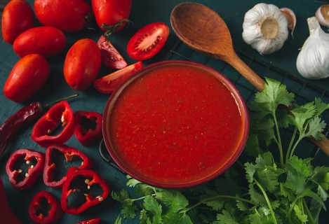Tomato sauce, tomatoes and sweet pepper, Georgian Satsebeli sauce, with ingredients on a dark