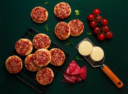 Mini pizzas, salami with mozzarella cheese, on the table, top view, no people