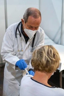 Vaccinator administers a vaccination, during the test run in the vaccination centre for corona