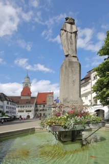 Tausendgüldenbrunnen with column, sculpture and water basin, town hall with church tower of St