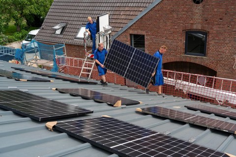 Installation of solar modules on the roof of a barn on a farm, over 240 photovoltaic modules are