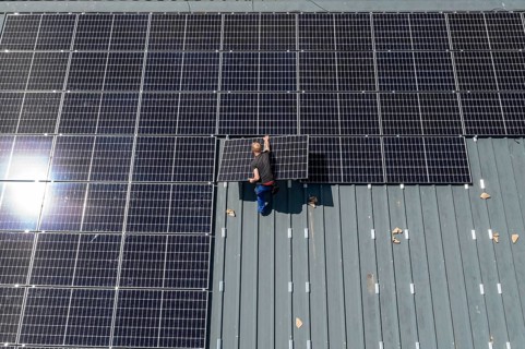 Installation of solar modules on the roof of a barn on a farm, over 210 photovoltaic modules are