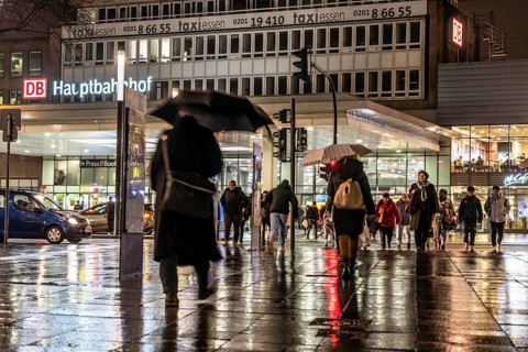 Passers-by at a pedestrian crossing, at the main railway station, rainy weather, city centre, in